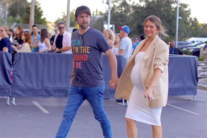 Stassi Schroeder & Beau Clark Cradle Her 25-Week Baby Bump In A Tight White Dress – Pic